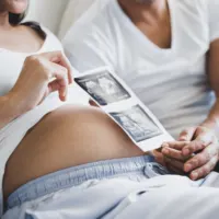 Husband and pregnant wife with ultrasound photos
