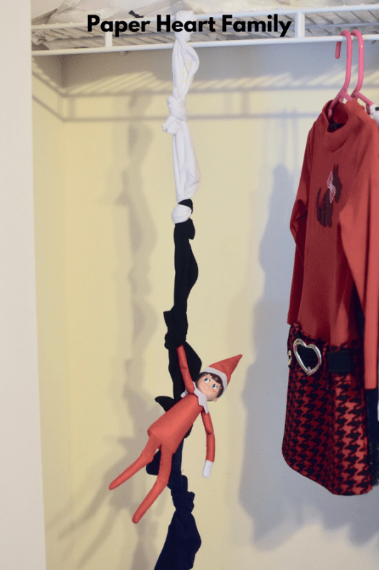 This elf on the shelf is ready for action and has made a rope out of socks to climb.