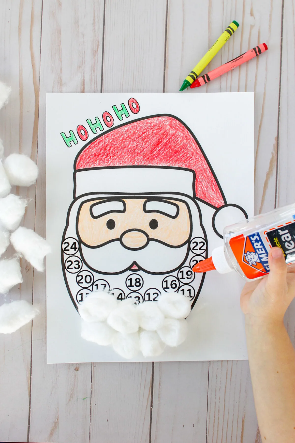 Kid glueing cotton balls to Santa's beard