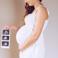 Woman holding ultrasound photos