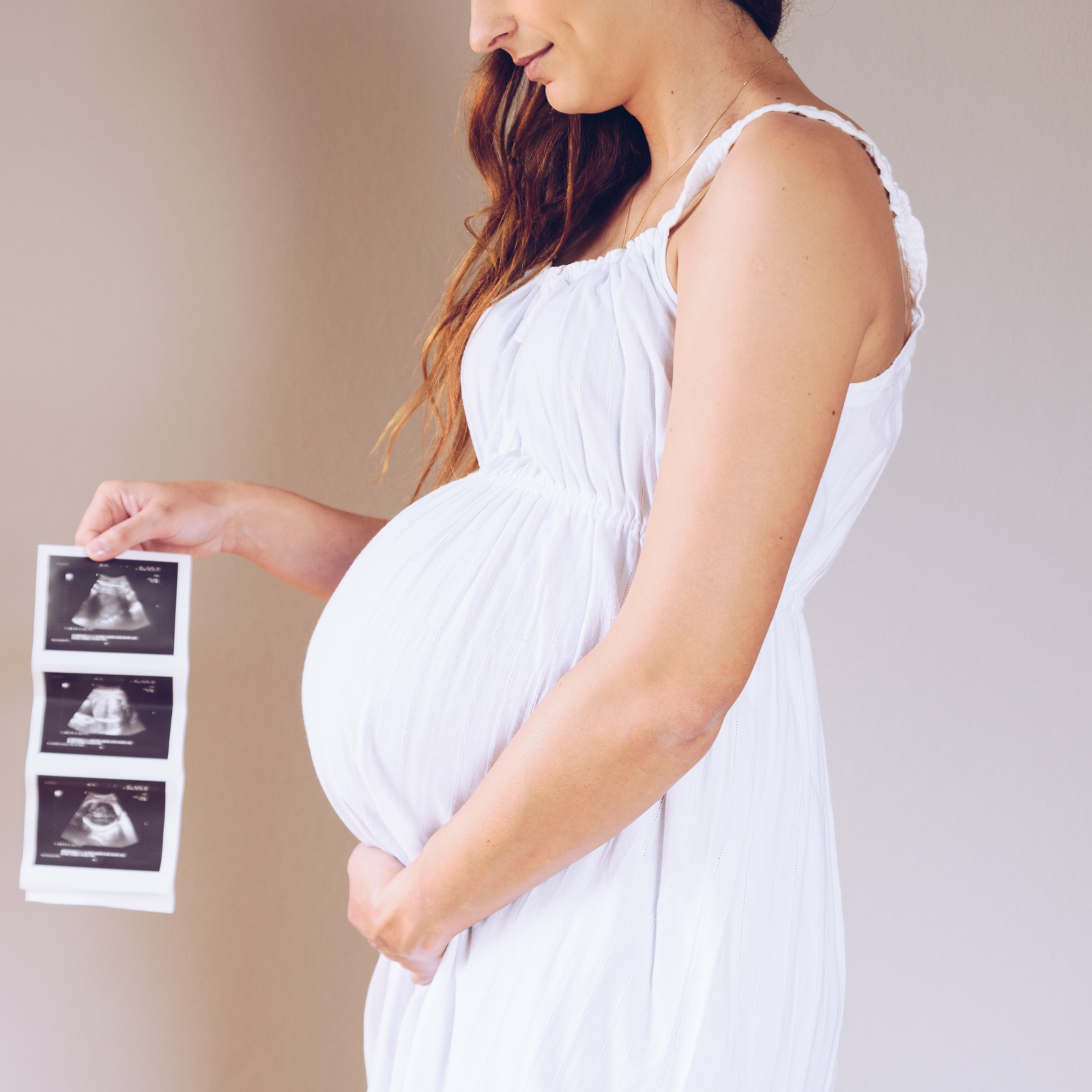 Woman holding ultrasound photos