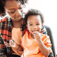 Toddler boy sitting on mom's lap- both smiling