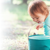 Little girl playing with a watering can
