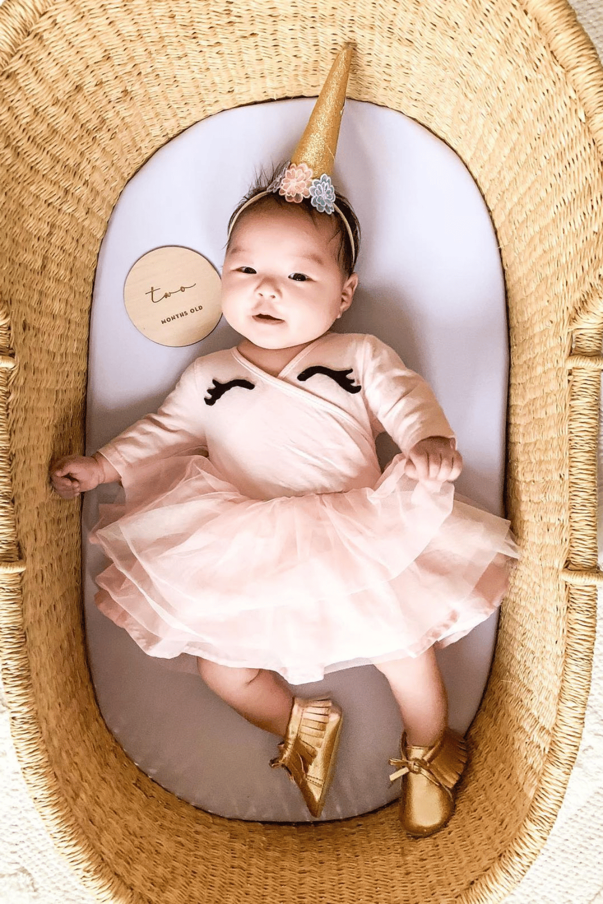 Baby girl with unicorn horn, pink tutu and unicorn eyelashes on her onesie