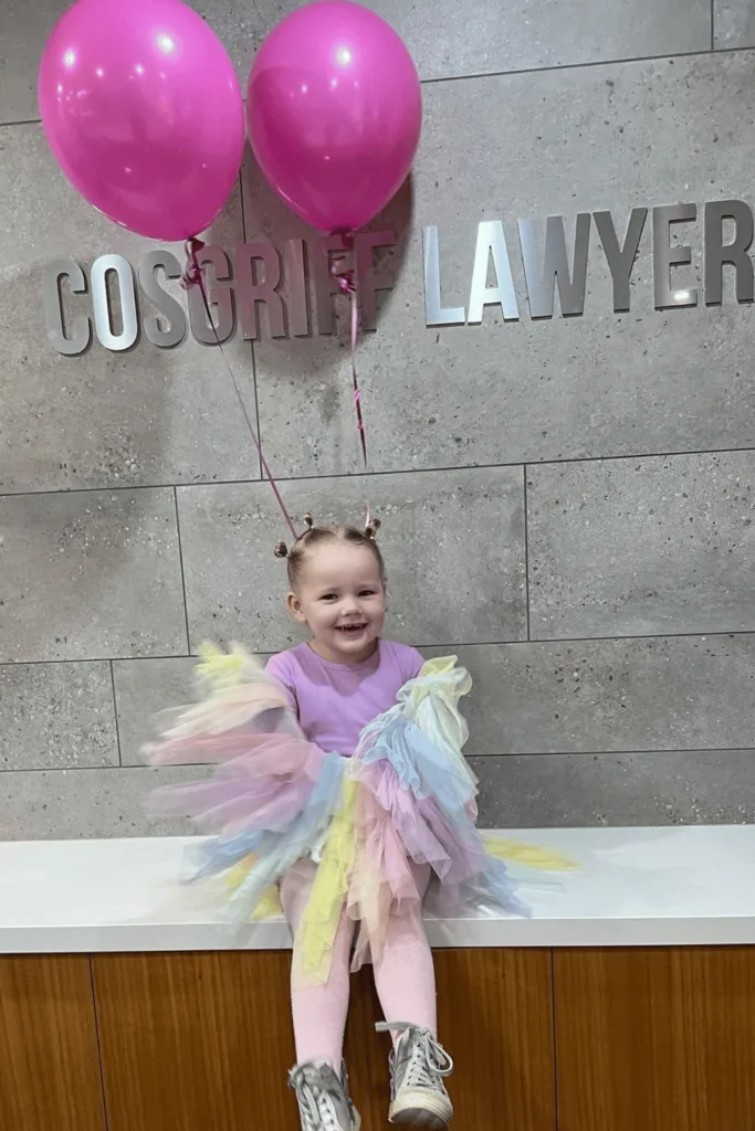 Helium balloons tied into girl's hair