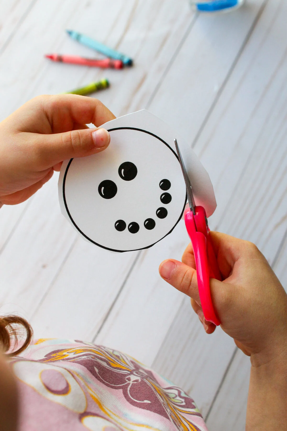 Child cutting out the snowballs to make the snowman