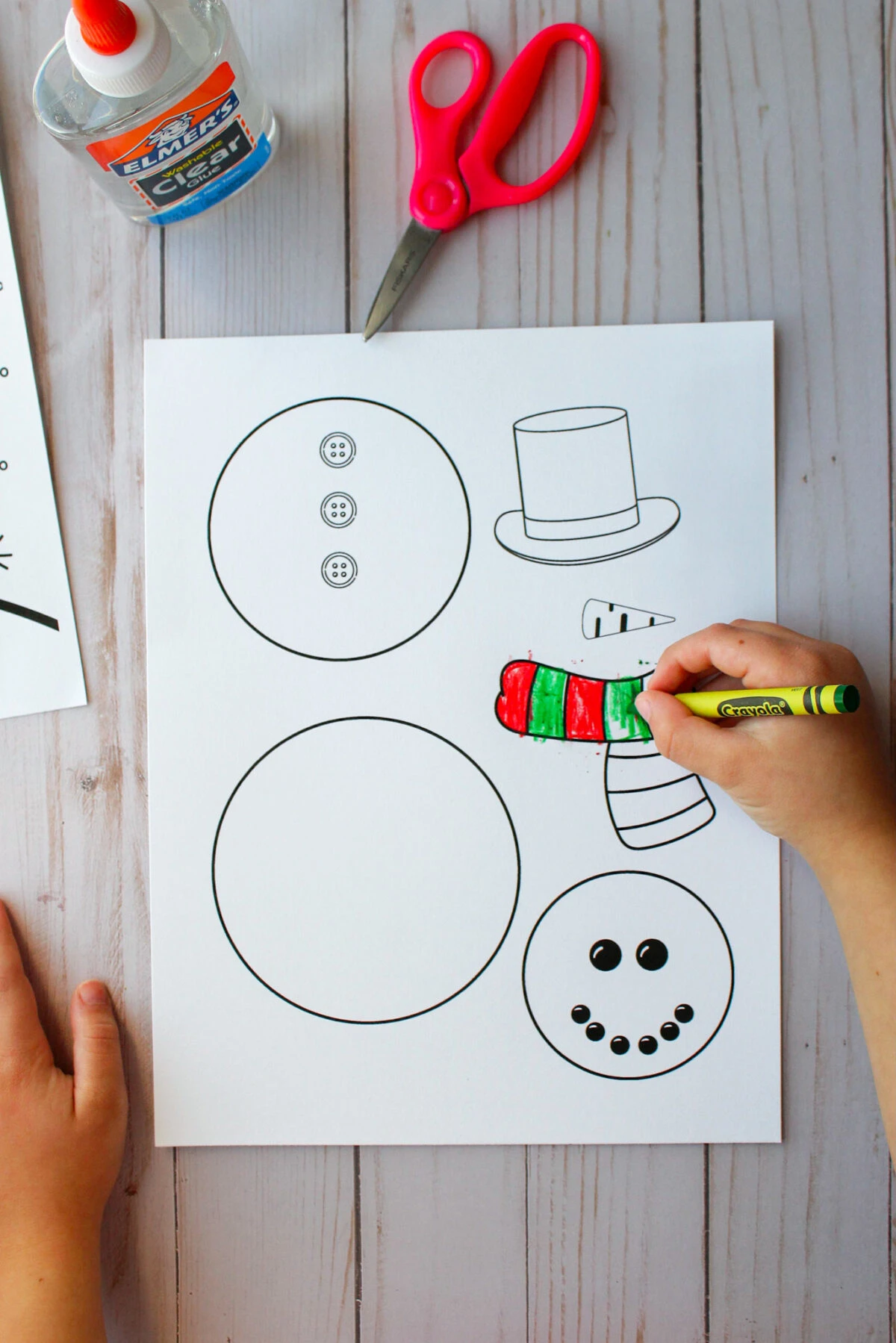 Girl coloring snowman's scarf